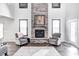 Cozy living room with a stone fireplace, hardwood floors, and grey armchairs at 12959 Girvan Way, Fishers, IN 46037