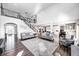 Bright living room with a staircase, grey couches, and an open floor plan to the modern kitchen at 12959 Girvan Way, Fishers, IN 46037