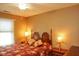 Bedroom showcasing a vibrant floral bedspread, traditional lamps, and a ceiling fan at 1401 Runningbrook Ln, Avon, IN 46123