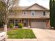 Charming two-story home featuring a manicured lawn and an attached two-car garage at 1401 Runningbrook Ln, Avon, IN 46123