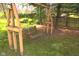 Relaxing wooden porch swing set under a large shade tree in the backyard, ideal for enjoying peaceful moments at 1401 Runningbrook Ln, Avon, IN 46123