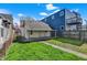 Property featuring a green backyard and a small white house extension with an inviting covered patio at 1422 Olive St, Indianapolis, IN 46203