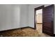 A room with outdated brown carpet and a dark wood door at 1422 Olive St, Indianapolis, IN 46203