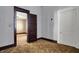 A room with outdated brown carpet and a closed interior door at 1422 Olive St, Indianapolis, IN 46203
