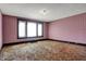 A living room with pink striped wallpaper, original dark trim, and a large window at 1422 Olive St, Indianapolis, IN 46203