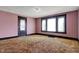 A living room with pink striped wallpaper, original dark trim, and a large window at 1422 Olive St, Indianapolis, IN 46203