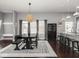 Bright dining space with hardwood floors and a modern light fixture, flowing into the kitchen at 1430 Fletcher Ave, Indianapolis, IN 46203