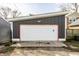 Detached garage featuring a white door with orange trim and modern security lighting at 1430 Fletcher Ave, Indianapolis, IN 46203