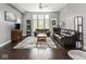 Spacious living room with hardwood floors, ceiling fan, large windows, and comfortable leather sofas at 1430 Fletcher Ave, Indianapolis, IN 46203