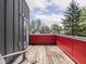 Outdoor deck area with wood floors with a bright red railing offering elevated views of neighborhood at 1430 Fletcher Ave, Indianapolis, IN 46203