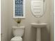 Elegant powder room featuring pedestal sink, decorative mirror, and stylish wall art at 15388 Manderley St, Fishers, IN 46040