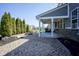 Spacious backyard features a stone fire pit, beautiful trees, and a covered patio, perfect for outdoor living at 15594 Garrano Ln, Fishers, IN 46040