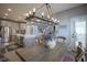 Dining room with contemporary lighting fixture adjacent to a kitchen with stainless appliances at 15594 Garrano Ln, Fishers, IN 46040
