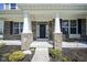 Charming front porch with brick pillars, beautiful front door with a wreath, and manicured landscaping at 15594 Garrano Ln, Fishers, IN 46040