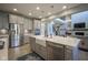 Kitchen island offers a farmhouse sink and overlooks a living area with fireplace, and a dining area at 15594 Garrano Ln, Fishers, IN 46040