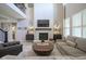 Spacious living room with a fireplace, high ceilings, and a view of the second-floor balcony at 15594 Garrano Ln, Fishers, IN 46040