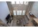 Bright living room with soaring ceilings, large windows, and a cozy fireplace, creating an inviting atmosphere at 15594 Garrano Ln, Fishers, IN 46040