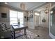 An office with a modern desk, stylish chair, and bright natural light, adjacent to the home's entry at 15594 Garrano Ln, Fishers, IN 46040