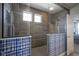 Luxurious walk-in shower featuring neutral tiling, transom windows, and glass enclosure at 15594 Garrano Ln, Fishers, IN 46040