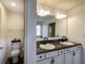 Bathroom with double sink vanity with granite counters, toilet with decorative bin, and a large mirror at 1583 Valdarno Dr, Greenwood, IN 46143