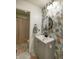 Well-lit bathroom featuring a floral accent wall, gray vanity, and round mirror at 1583 Valdarno Dr, Greenwood, IN 46143