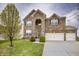 Inviting two-story brick home with tidy front lawn, healthy tree, and an attached three-car garage at 1583 Valdarno Dr, Greenwood, IN 46143