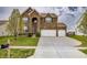 Beautiful two-story brick home with lush green lawn, mature tree, and spacious three-car driveway at 1583 Valdarno Dr, Greenwood, IN 46143