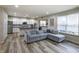 An open-concept living room and kitchen area with gray sectional sofa and lots of light at 1583 Valdarno Dr, Greenwood, IN 46143