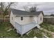 Back of the beige home featuring a gray deck, white door, and matching gray shingles at 1623 N Centennial St, Indianapolis, IN 46222