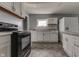 Well-lit kitchen featuring white cabinets and sleek black appliances against gray tile at 1623 N Centennial St, Indianapolis, IN 46222