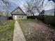 Back exterior view of house with a long cement sidewalk and a partially grass and dirt-filled backyard at 1626 S State Ave, Indianapolis, IN 46203