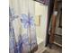 Bathroom with blue flower shower curtain, tub and cream tile at 1647 S Plateau Cir, Martinsville, IN 46151