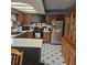 Charming kitchen with black and white tile floor, a stainless steel refrigerator, and wooden cabinets with modern countertop space at 1647 S Plateau Cir, Martinsville, IN 46151