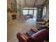 Spacious living room featuring a stone fireplace, exposed beams, and large windows with views of the outdoor deck and scenery at 1647 S Plateau Cir, Martinsville, IN 46151