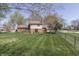 Spacious backyard featuring mature trees, a well-manicured lawn and neighboring houses at 1772 Woodridge Pl, Greenwood, IN 46143