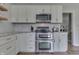 Well-lit kitchen with stainless steel appliances and modern white cabinets and light countertops at 1772 Woodridge Pl, Greenwood, IN 46143