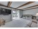 Well-lit living room with beamed ceiling, large TV, and sliding glass door to outdoor patio at 1772 Woodridge Pl, Greenwood, IN 46143