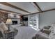 Bright living room with beamed ceiling, fireplace, built-in shelving, and sliding glass door to outdoor patio at 1772 Woodridge Pl, Greenwood, IN 46143