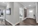 Open hallway with wood-look flooring, leading to a living area, complemented by an accent mirror at 19414 Mcbee Ave, Westfield, IN 46074