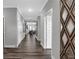 Inviting hallway featuring wood-look flooring, neutral gray walls, white trim and decorative mirror at 19414 Mcbee Ave, Westfield, IN 46074