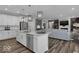 Open-concept kitchen flows into the living room, showcasing stainless appliances and island seating at 19414 Mcbee Ave, Westfield, IN 46074