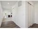 Hallway with hard surface floors leading to the kitchen, featuring white walls and closet space at 1976 White Oak Ln, Shelbyville, IN 46176