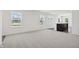 Bright living room with neutral carpet, white walls, and a view of the outside through the windows at 1976 White Oak Ln, Shelbyville, IN 46176