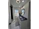 Modern bathroom with updated vanity, fixtures, and a framed circular mirror at 2029 Winton Ave, Indianapolis, IN 46224