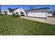 Exterior shot of the home showing the large, luscious front yard, deck, and detached garage at 2029 Winton Ave, Indianapolis, IN 46224
