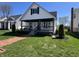 Charming exterior of a two-story home with front porch, landscaped yard, and brick walkway at 2029 Winton Ave, Indianapolis, IN 46224