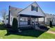 Charming two-story home featuring a covered front porch, manicured lawn and stylish black and white color palette at 2029 Winton Ave, Indianapolis, IN 46224