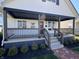 This covered front porch is stylishly appointed with a modern railing, custom welcome sign, and upgraded trim at 2029 Winton Ave, Indianapolis, IN 46224