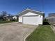 A single shot of the detached two car garage with a large concrete driveway and white door at 2029 Winton Ave, Indianapolis, IN 46224