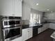 Kitchen with stainless steel appliances, granite countertops, and white cabinets for modern look at 2029 Winton Ave, Indianapolis, IN 46224